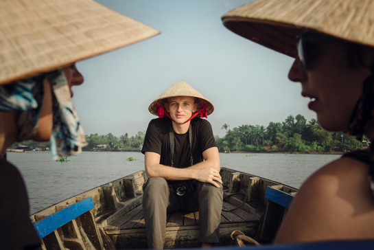 Can Tho, Vietnam - April 02, 2016: Tourist in Vietnamese hat going on a trip on Mekong delta by boat.