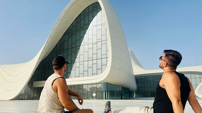 Two men sitting in front of Heydar Aliyev Center Baku Azerbaijan