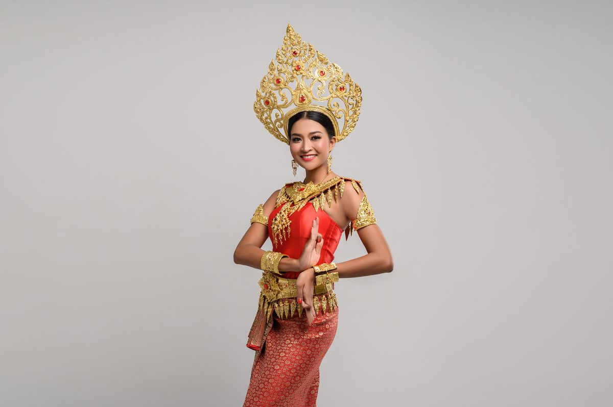 Balinese woman in traditional ceremonial costume posing gracefully at a temple ceremony in Bali