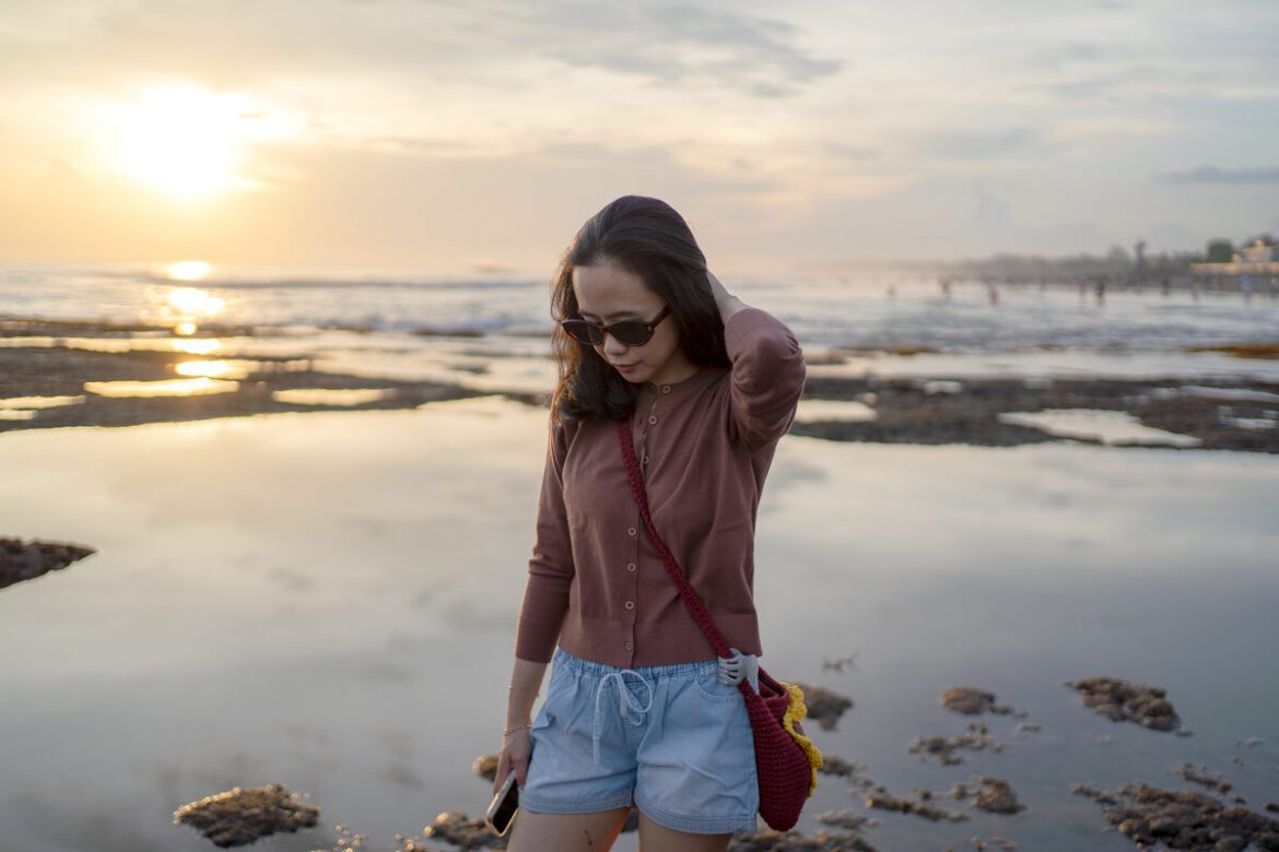 Sunset over Seminyak beach with silhouettes of travelers